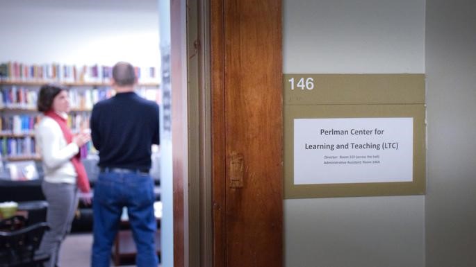 Sign for Perlman Center for Learning and Teaching outside the door of a room where two faculty members are talking with each other. 